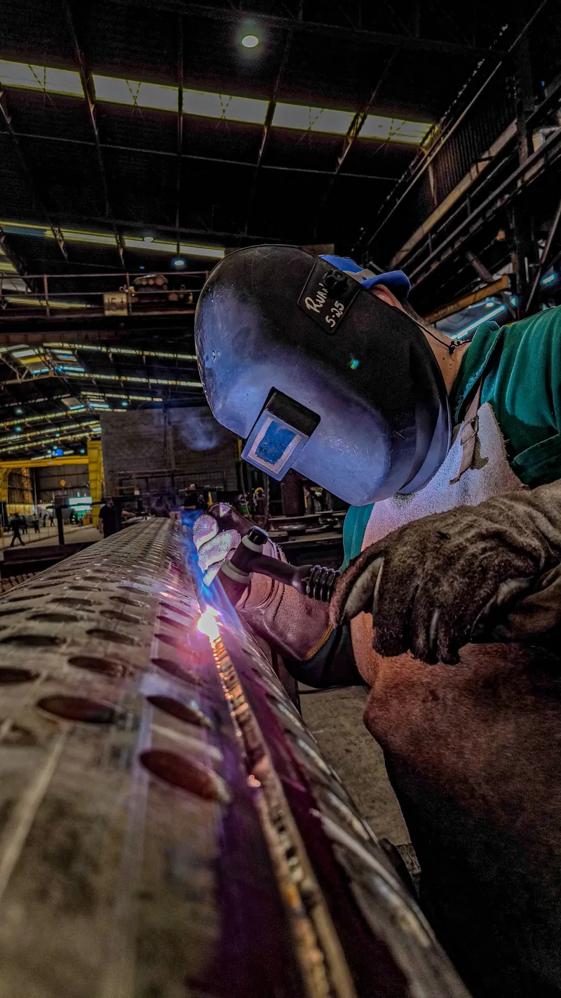 Soldadura de componente metálico em ambiente industrial